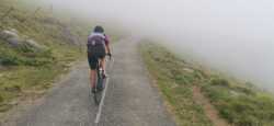 Ciclistas ascendiendo entre la niebla en Apanize-Landerre 